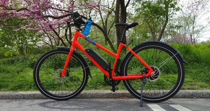 Bicicleta RadMission en carril bici en Central Park en frente del árbol en flor en la Ciudad de Nueva York